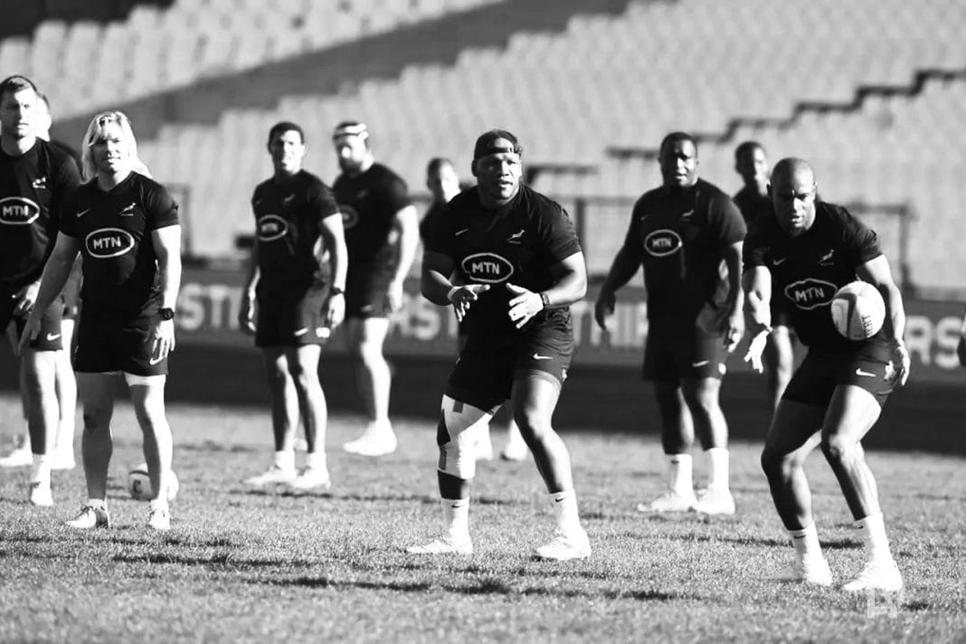 Rugby players huddled intensely during a match, expressions a mix of determination and frustration.